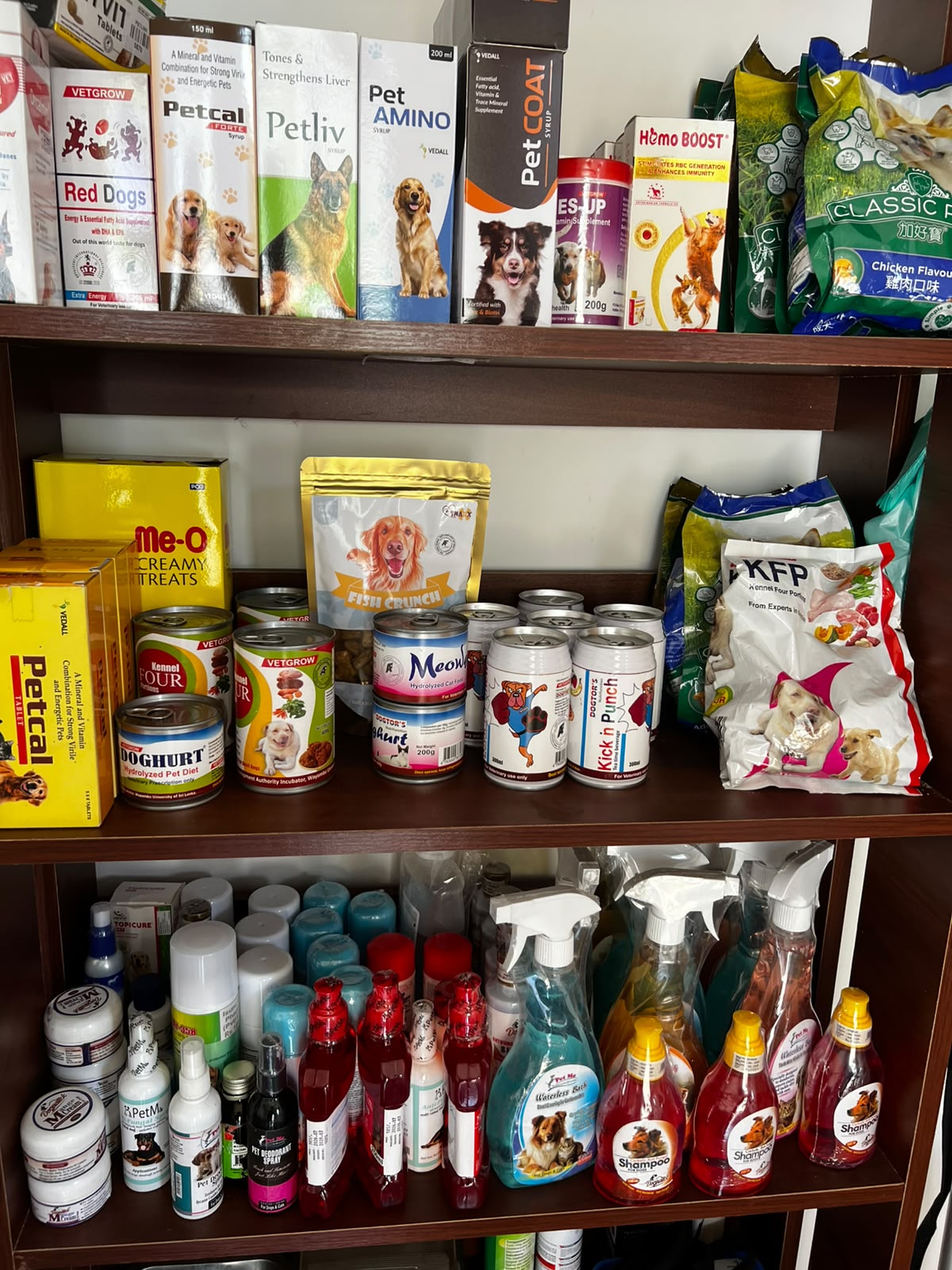 Pharmacy shelving unit at V Pet Care stocked with veterinary supplements, pet food brands including Petcal, Petliv, Pet AMINO, and grooming products